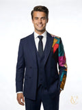 Young man wearing a tailored navy 3-Piece Suit - Multicolour | Vellure Couture with a white shirt and black tie, featuring a vibrant multicolour patchwork sleeve detail.