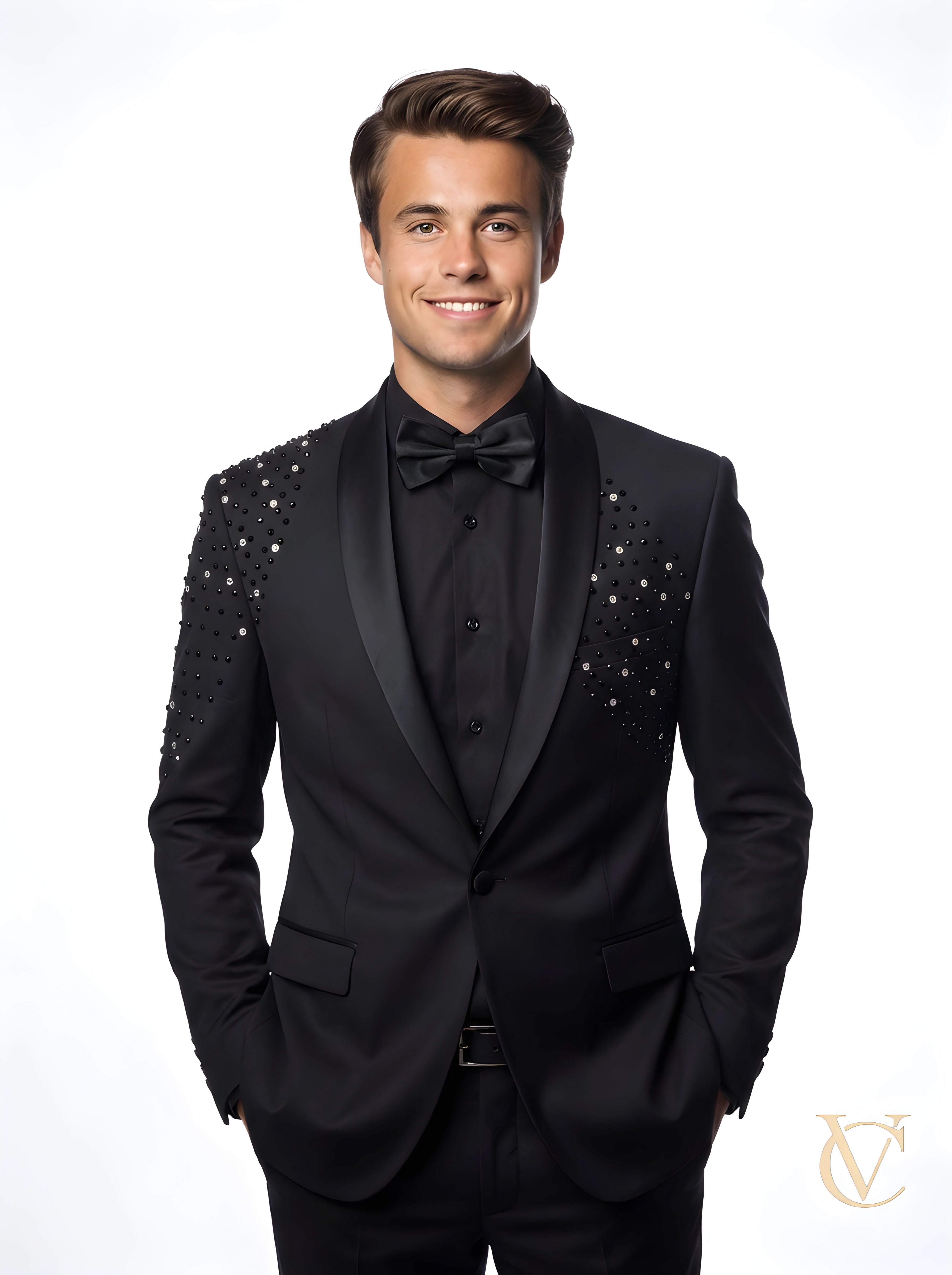 Young man wearing a tailored black tuxedo with crystal embellishments on the shoulders, a black shirt, and a bow tie, showcasing the Suit - Black | Vellure Couture.