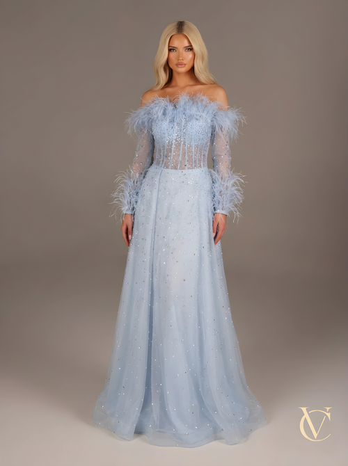 Model wearing Crystal feather Dress - Blue | Vellure Couture, featuring a sheer bodice with crystal embellishments, off-shoulder feather details, and a flowing blue skirt.