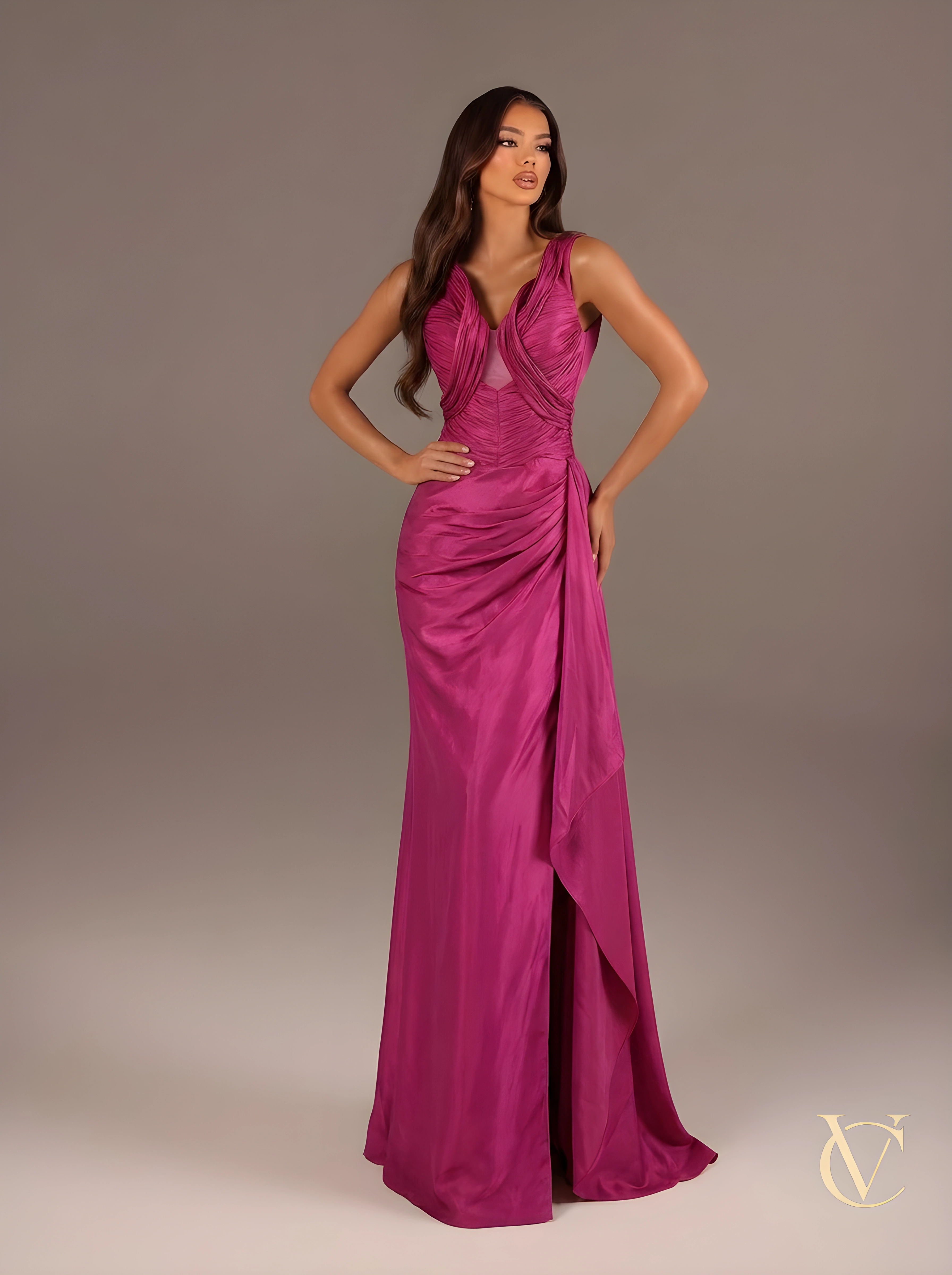 Woman wearing a vibrant pink evening gown against a neutral background