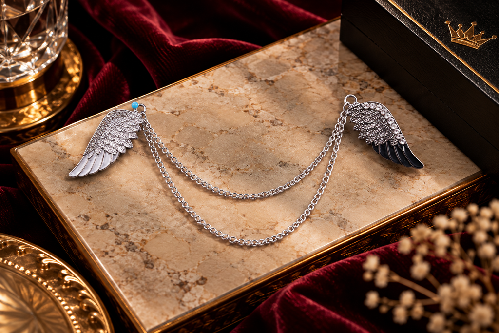 Silver and black wing lapel chain on luxury marble background | Vellure Couture®